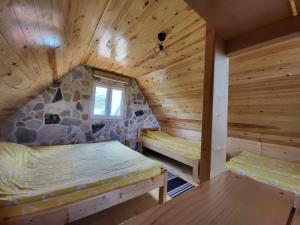 a log cabin with two beds and a window at Mountain house WILD GOAT in Žabljak