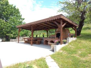 a wooden pavilion with a picnic table in a park at Casa Alex in Curtea de Argeş