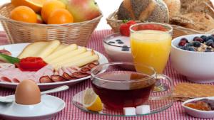 una mesa con desayuno de fruta y zumo en Priamos Hotel Erato en Atenas