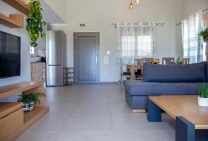 een woonkamer met een blauwe bank en een tafel bij VILLA ALKISTIS in Lefkada