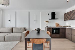een woonkamer met een tafel en een bank bij Angielska Grobla - City Center, Marina & Parking by Downtown Apartments in Gdańsk