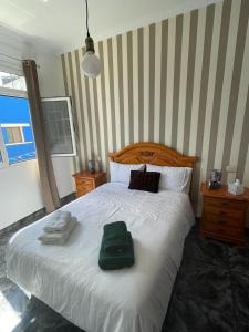 a bedroom with a bed with a green pillow on it at Pico Lomito House in Moya