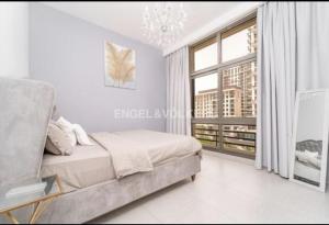a bedroom with a bed and a large window at TOWN SQUAR PARK VIEW in Dubai