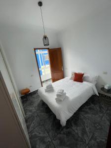 a bedroom with a large white bed with red pillows at Pico Lomito House in Moya