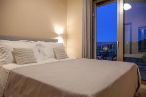 een slaapkamer met een groot wit bed met een raam bij VILLA ALKISTIS in Lefkada +26 foto's