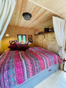 ein Schlafzimmer mit einem großen Bett in einer Hütte in der Unterkunft Maringotka Lipenka u Lipenské přehrady na Šumavě in Hořice na Šumavě