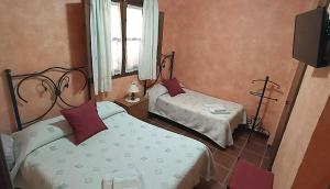 sypialnia z dwoma łóżkami i oknem w obiekcie Casa Rural Aguascebas w mieście Mogón