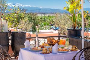 Riad la clé d'or & spa في مراكش: طاولة مع أطباق من الطعام على شرفة