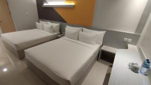 Postel nebo postele na pokoji v ubytování Agogo Downtown Hotel Surabaya