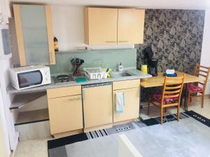 eine kleine Küche mit einer Spüle und einer Mikrowelle in der Unterkunft Ferienwohnung, 2 Zimmer, Küche,Bad in Staufenberg