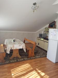 een keuken met een tafel en een witte koelkast bij Guest House AREVIK in Artsvakar