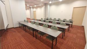 a row of tables and chairs in a room at Agogo Downtown Hotel Surabaya in Surabaya