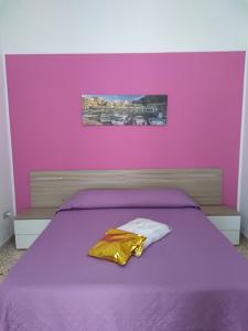 カステッランマーレ・デル・ゴルフォにあるCarpe Diem Apartmentsの紫の壁のベッドが備わる紫のベッドルーム1室が備わります。