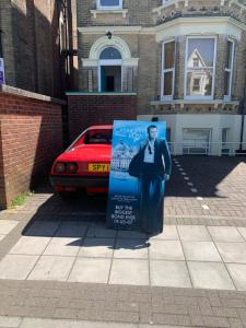 een bord op een stoep voor een auto bij Southsea Royale Studio, James Bond, Parking, Seafront in Portsmouth