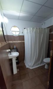 a bathroom with a sink and a shower curtain at Aires de Campo, casa quinta in Concordia +13 photos