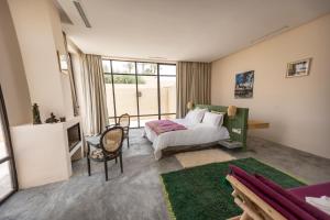 a bedroom with a bed and a large window at Bakkal Farm Agrolodge in Marrakech