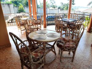 a restaurant with tables and chairs on a patio at Airport Side Hotel Entebbe in Entebbe