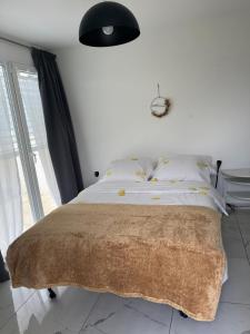 a bedroom with a bed with a blanket on it at Au bord de l’eau in Orpund
