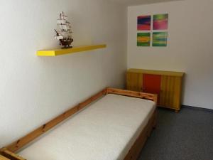 a bedroom with a bed and a shelf on the wall at Ferienwohnung Mertins in Boltenhagen