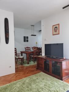 a living room with a flat screen tv and a table at Sara in Mostar +6 photos
