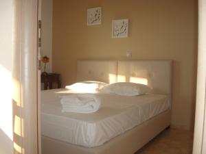 a bedroom with a bed with white sheets and pillows at Merlot Village Rental Properties in Kariá +49 photos