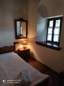 a bedroom with a bed and a mirror and a window at ΘΕΤΙΣ in Vyzitsa