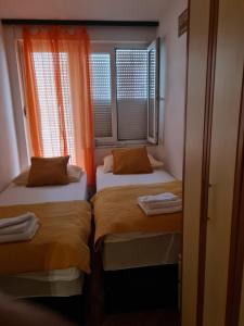 a small room with two beds and a window at Sara in Mostar