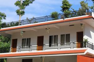 a building with a balcony on top of it at Sri Lakshmi Estates in Siddapur