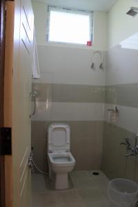 Elle comprend une petite salle de bains pourvue de toilettes et d'une fenêtre. dans l'établissement Sri Lakshmi Estates, à Siddapur
