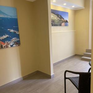 ナポリにあるRoyal Danteの壁に絵画が2点あり、椅子が備わるお部屋