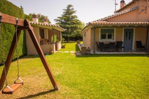 a yard with a swing in front of a house at KOUROUTA VILLAS in Amalias