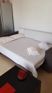 un letto bianco con un cappello rosso su un tavolo di Sarrande, big one bedroom apartment at the center a Sarandë
