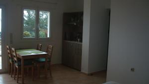 a kitchen with a table and chairs and a window at Merlot Village Rental Apartments in Kariá