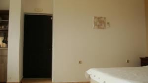 a bedroom with a black door and a bed at Merlot Village Rental Apartments in Kariá