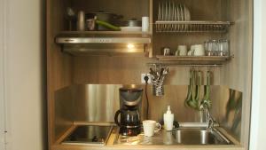 a kitchen with a coffee maker and a sink at Merlot Village Rental Apartments in Kariá