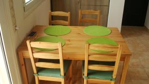 a wooden table with green plates on top of it at Merlot Village Rental Apartments in Kariá