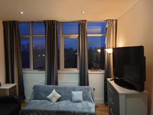 een woonkamer met een bank en een groot raam bij City Sparrow Nest -12W in Londen