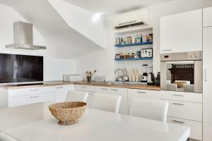 cocina blanca con mesa blanca y sillas en Vila Adriana, en Izola