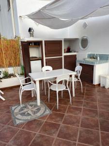 a kitchen with a white table and chairs in a kitchen at Casa ISABELLA loc turist br in Lipari