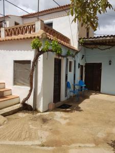 a house with two chairs and a tree in front of it at Granja de Matias in Cádiar