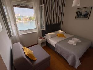 a small hotel room with a bed and a window at Accommodation Jarula in Zadar