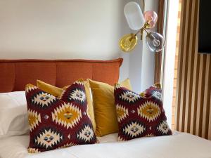 Una cama con algunas almohadas. en Apartament Carmel Stegna Park, en Stegna