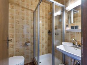 a bathroom with a shower and a toilet and a sink at Au Pension in Söll