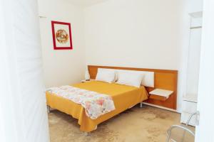 a bedroom with a bed with a yellow bedspread at Relax in Vieste