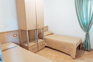 a small bedroom with two beds and a mirror at Relax in Vieste