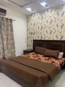 Un dormitorio con una cama y una pared con pájaros. en Independent Villa in DHA Phase 6 Lahore Three 3 Bedroom Full House en Lahore