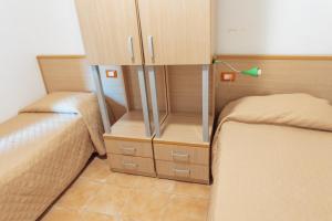 a small bedroom with two beds and a cabinet at Relax in Vieste