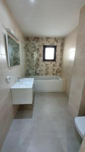 uma casa de banho com uma banheira, um lavatório e um WC. em Appartement Corniche en bord de mer em Sousse