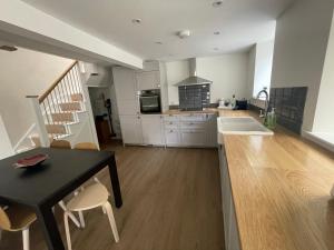 a kitchen with a table and chairs and a kitchen with a sink at Holiday House at 22, Contemporary 3 bedroom cottage in historic Wigtown in Wigtown