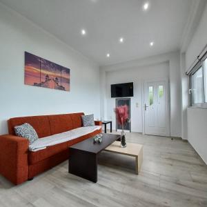 a living room with a couch and a coffee table at Zoggos Apartment in Áyios Pétros